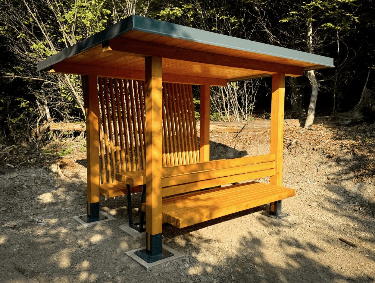 Drevený prístrešok na posedenie v lese